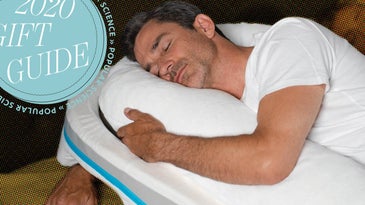 a man laying on a wedge pillow