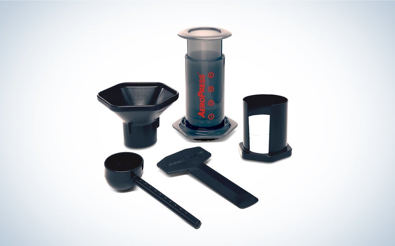 an AeroPress coffee press with funnel, scoop, stirrer, microfilters, and filter holder accessories