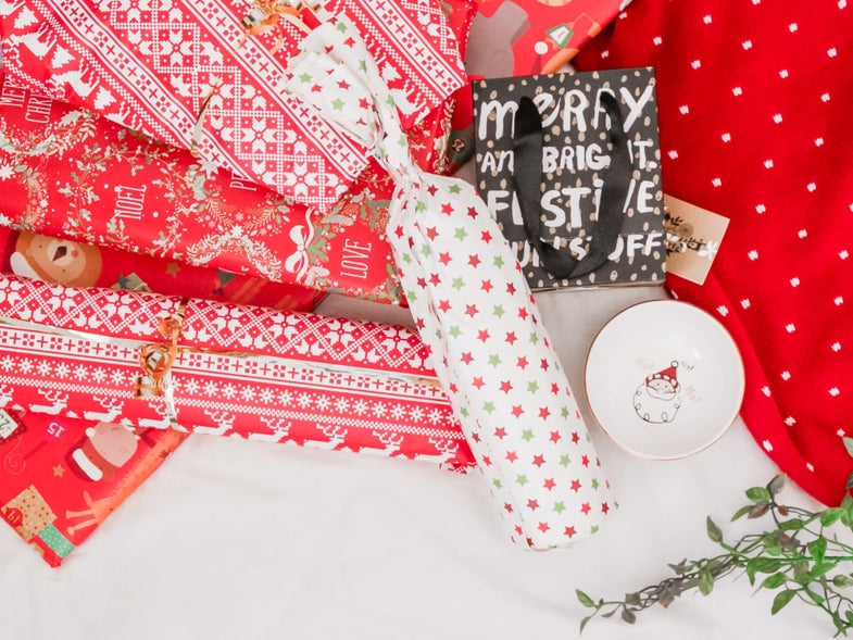 a photo of wrapping paper and a Christmas gift shaped like a cylinder