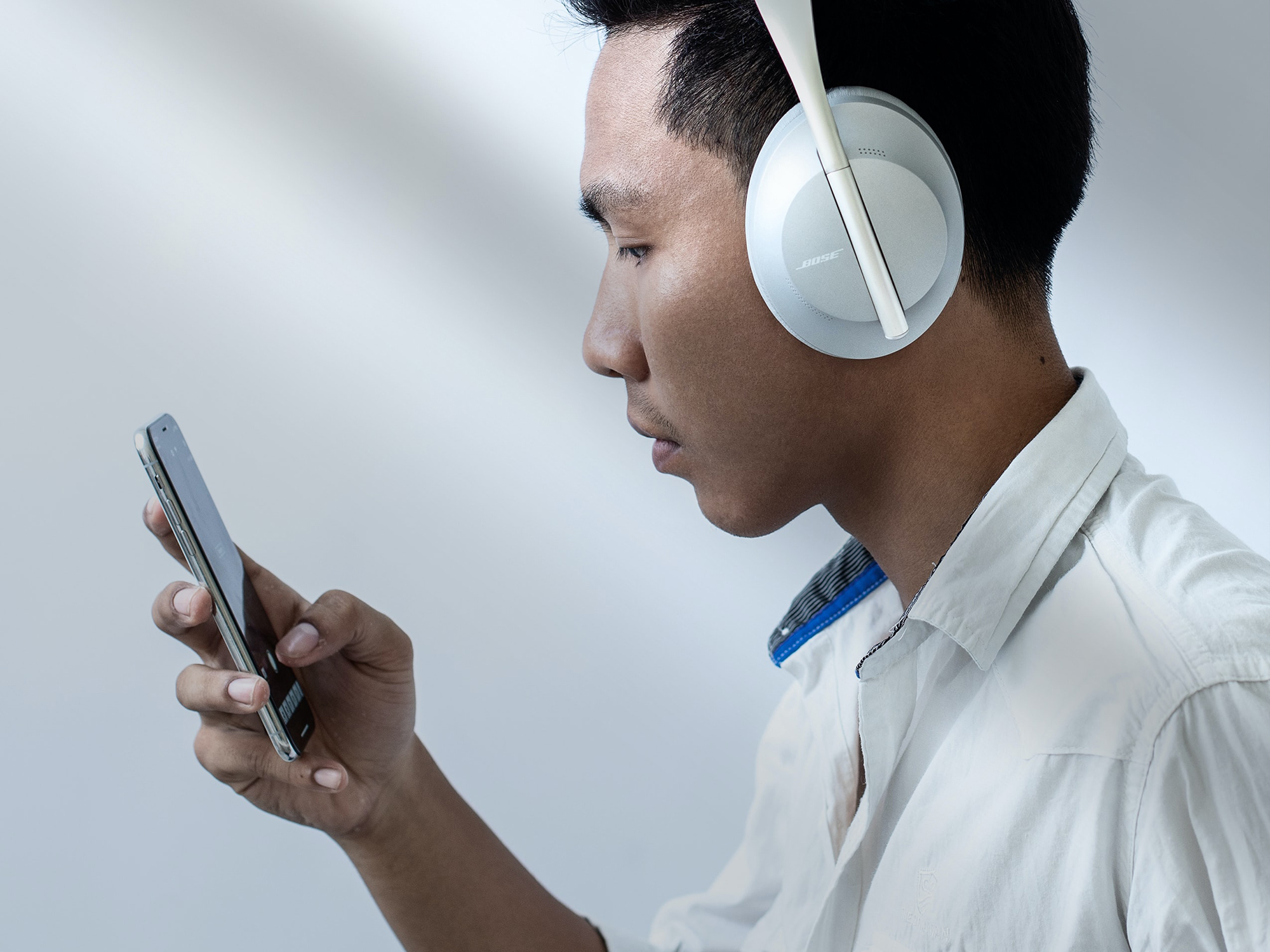 Person with headphones playing audio on smartphone