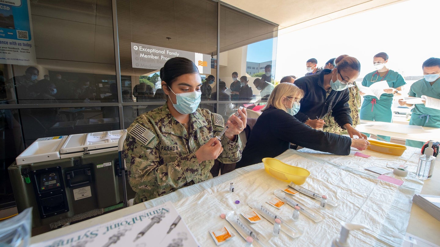 A US sailor at the Naval Medical Center in San Diego, California, prepares Pfizer COVID-19 vaccines for rollout
