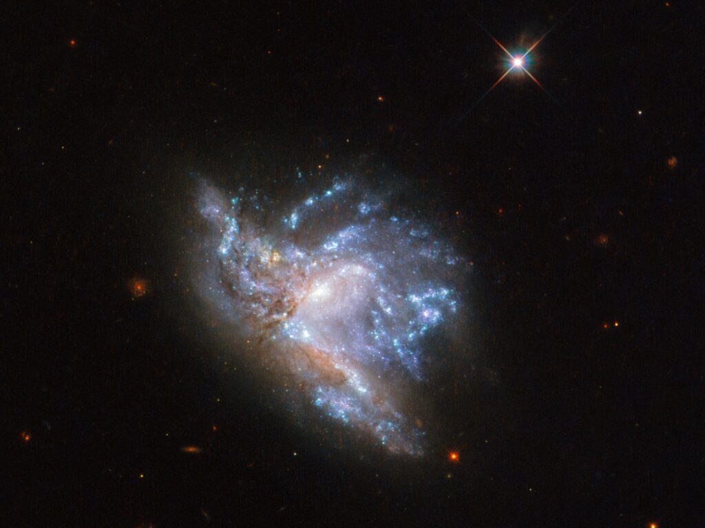 Located in the constellation of Hercules, about 230 million light-years away, NGC 6052 is a pair of colliding galaxies. They were first discovered in 1784 by William Herschel and were originally classified as a single irregular galaxy because of their odd shape. However, we now know that NGC 6052 actually consists of two galaxies that are in the process of colliding. This particular image of NGC 6052 was taken using the Wide Field Camera 3 on the NASA/ESA Hubble Space Telescope.