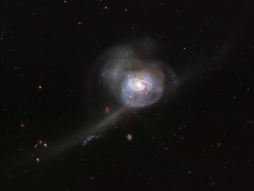Appearing within the boundless darkness of space, the NASA/ESA Hubble Space Telescopeâs snapshot of NGC 34 looks more like an otherworldly, bioluminescent creature from the deep oceans than a galaxy. Lying in the constellation Cetus (The Sea Monster), the galaxyâs outer region appears almost translucent, pinpricked with stars and strange wispy tendrils. The main cause for this galaxyâs odd appearance lies in its past. If we were able to reverse time by a few million years, we would see two beautiful spiral galaxies on a direct collision course. When these galaxies collided into one another, their intricate patterns and spiral arms were permanently disturbed. This image shows the galaxy's bright centre, a result of this merging event that has created a burst of new star formation and lit up the surrounding gas. As the galaxies continue to intertwine and become one, NGC 34âs shape will become more like that of an peculiar galaxy, devoid of any distinct shape.Â  In the vastness of space, collisions between galaxies are quite rare events, but they can be numerous in mega-clusters containing hundreds or even thousands of galaxies.