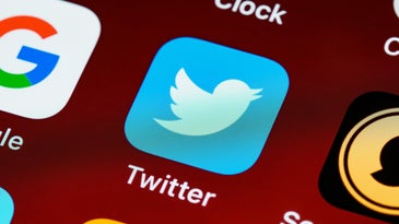 Twitter icon on a smartphone with other app icons.