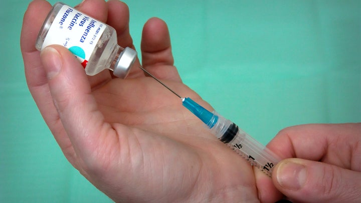 Close up of influenza vaccine shot being prepared.
