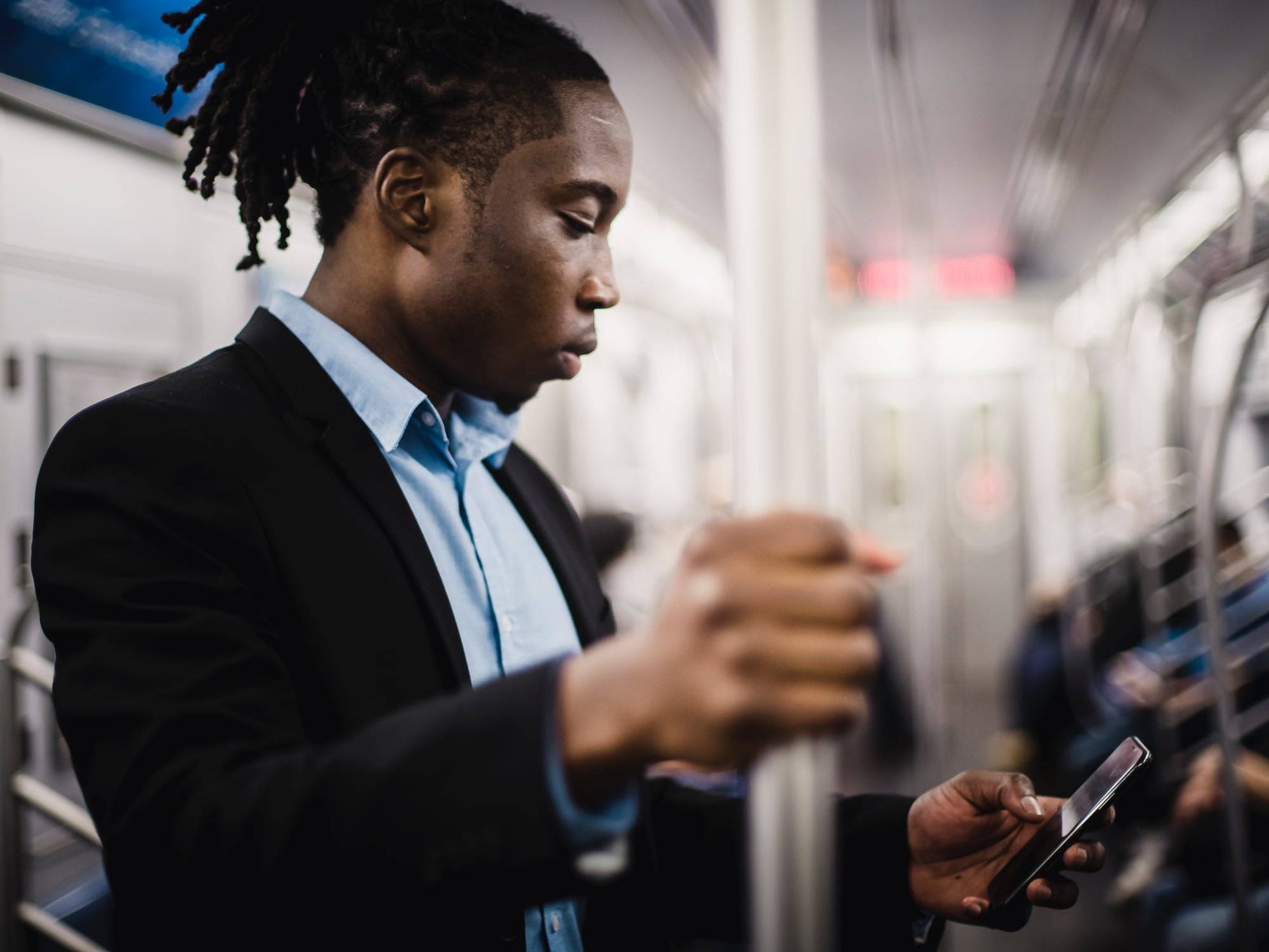 Person on a New York City subway train texting on their phone.