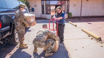 National Guard members dressed in camo dropping off COVID-19 PPE at a health clinic in New Mexico