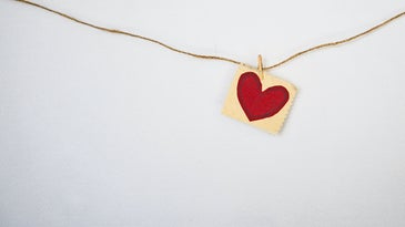 heart on a piece of paper that is hanging on a string