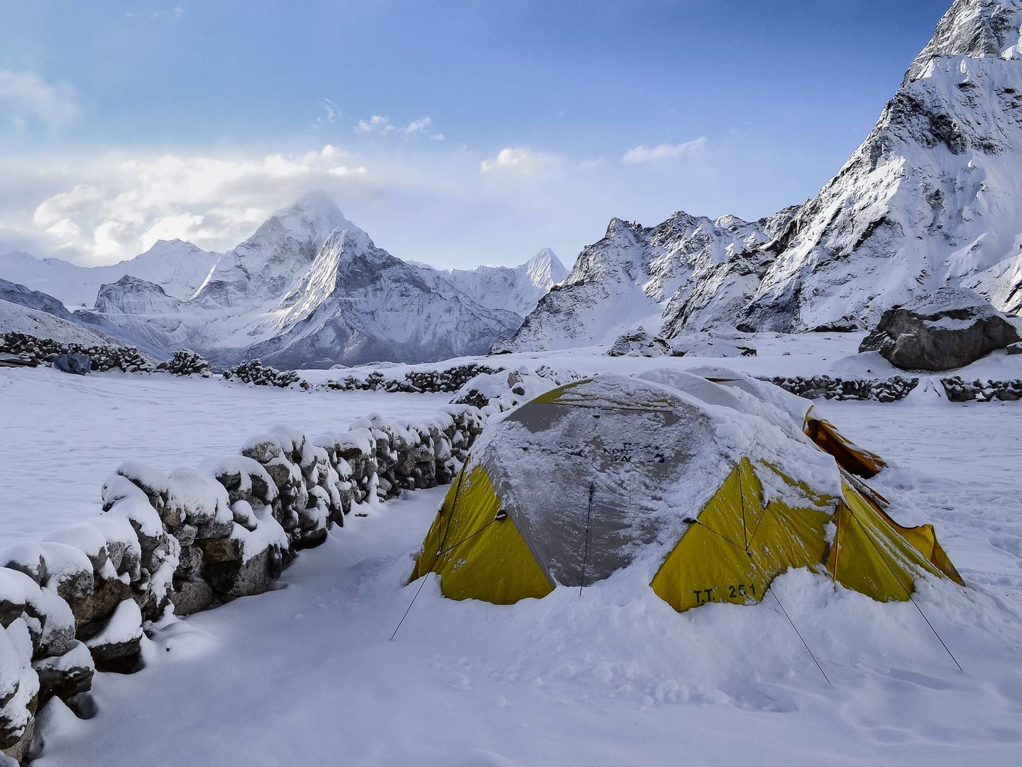 Green camping tent in the middle of a snowy mountain