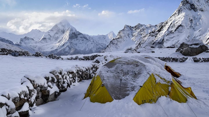 Green camping tent in the middle of a snowy mountain