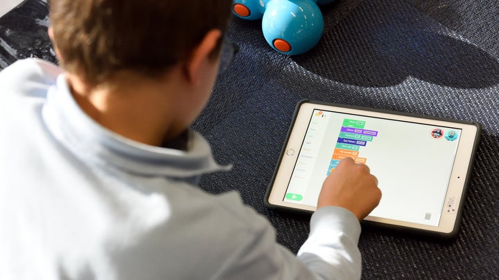 kid with glasses playing on an ipad with stem toys for kids