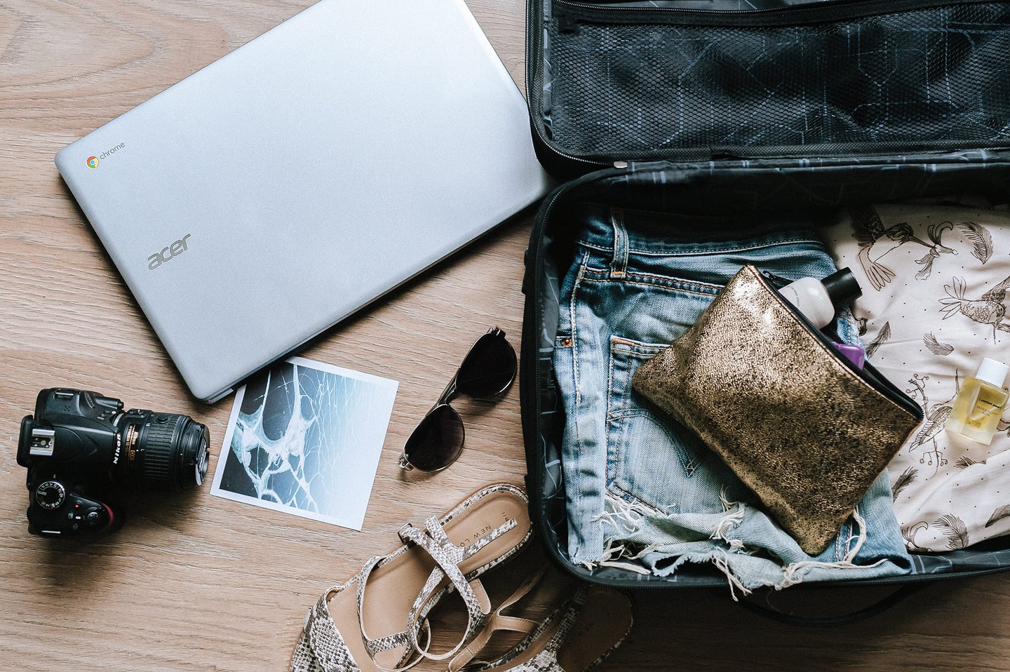 suitcase, laptop, sunglasses, camera, and other travel gear for the best gifts for travelers