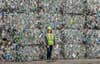 spokesperson for Waste Management stands with bales of plastic garbage