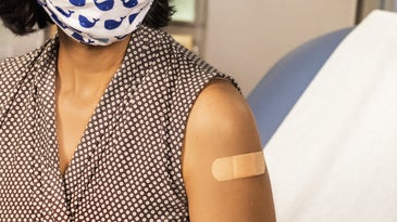 Woman wearing mask in doctor's office after receiving COVID-19 vaccine.