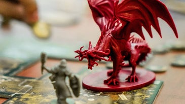 A plastic piece depicting a menacing plastic dragon on a board game
