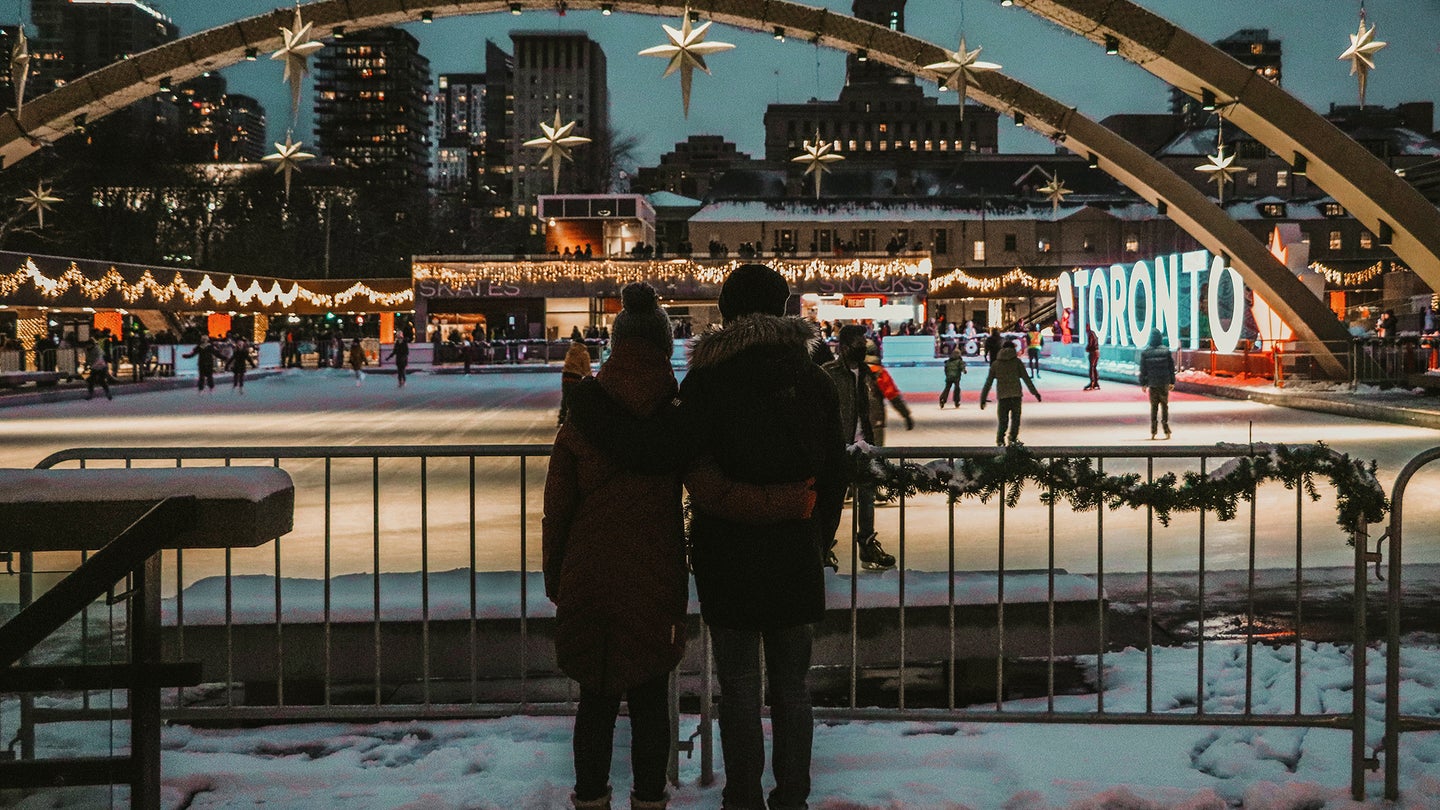 two people hugging each other in front of a lit up ice skating rink