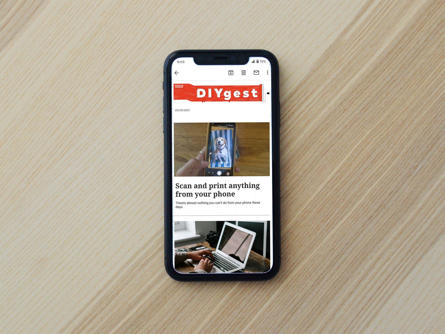 iPhone on a wooden table with a newsletter on the screen