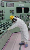 Scientist holding an earthquake railing in a Fukushima Daiichi control room