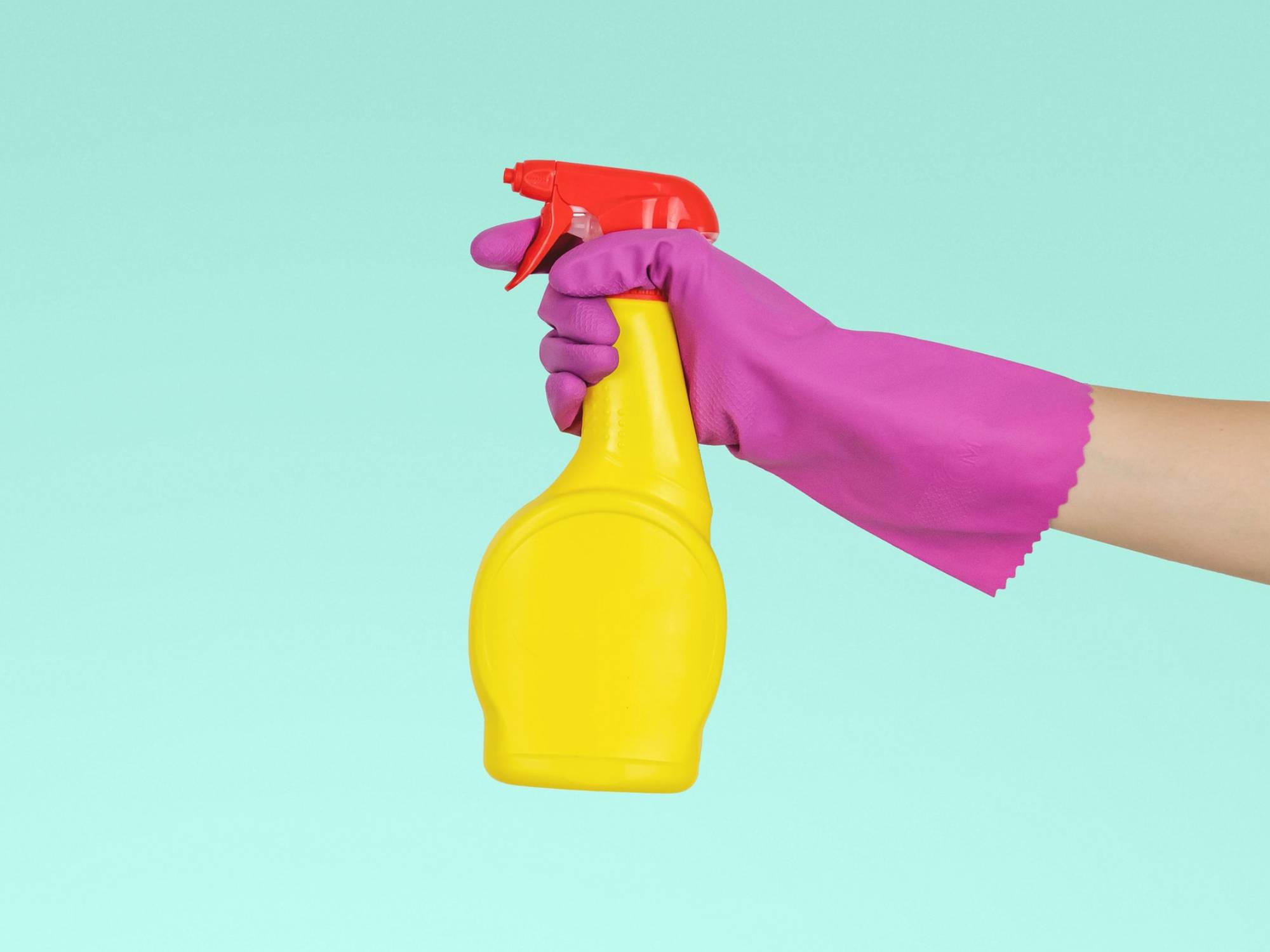 Hand in rubber gloves with a cleaning product sprayer