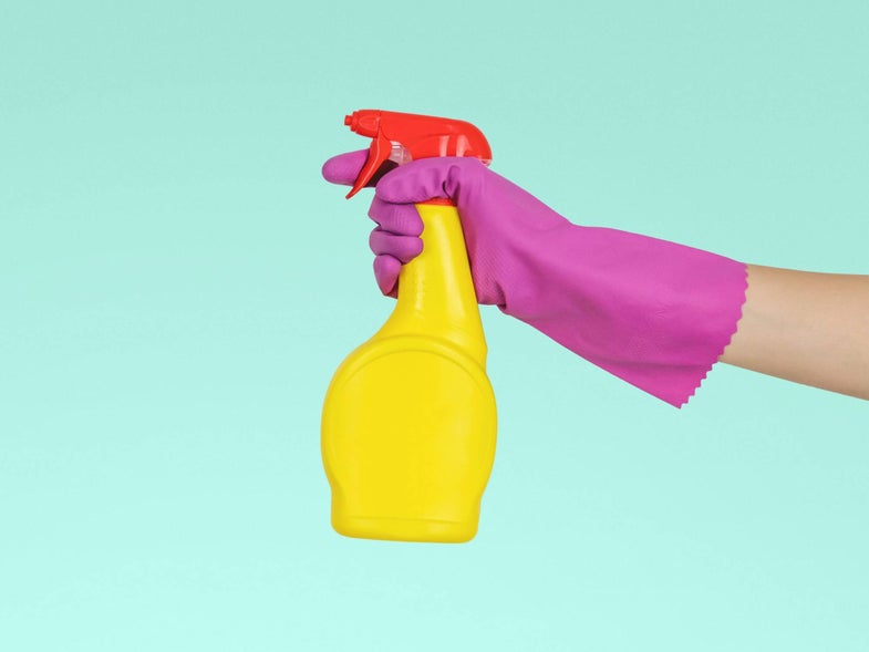 Hand in rubber gloves with a cleaning product sprayer