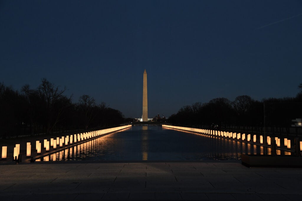 Washington Memorial at night with rows of lights along a pool