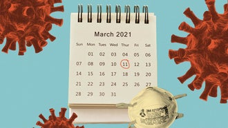 A calendar with the page for March 2021 displayed and a red circle around Thursday the 11th sits next to an N95 mask on a blue background surrounded by red illustrations of the coronavirus.