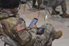 A soldier holds a smartphone.