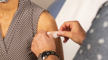 doctor putting bandaid on arm after person gets a vaccine