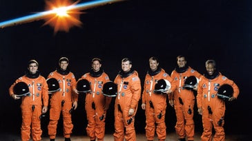 The NASA STS-39 shuttle crew in orange astronaut suits on a space backdrop