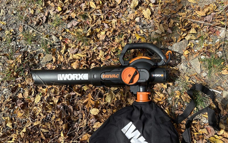 The WORX 12 TRIVAC 3-in-1 Electric Leaf Blower/Mulcher/Yard Vacuum sitting on top of a pile of leaves
