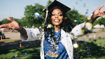 woman throwing glitter in front of herself wearing a graduation cap
