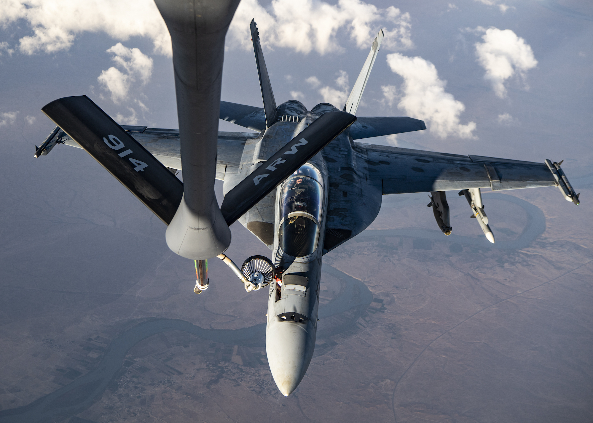 A F/A-18 Super Hornet is refueled the traditional way: by an aircraft with humans on board.