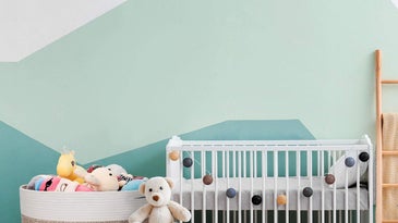 kid's room with a crib, toy basket, and other decorations