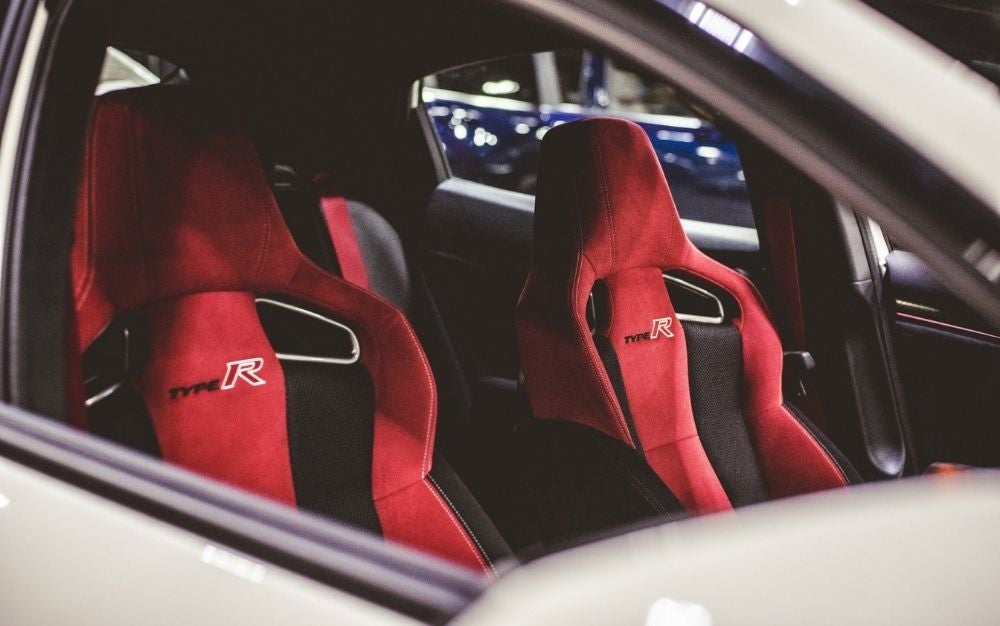 Two red seat covers with written Type R on them.