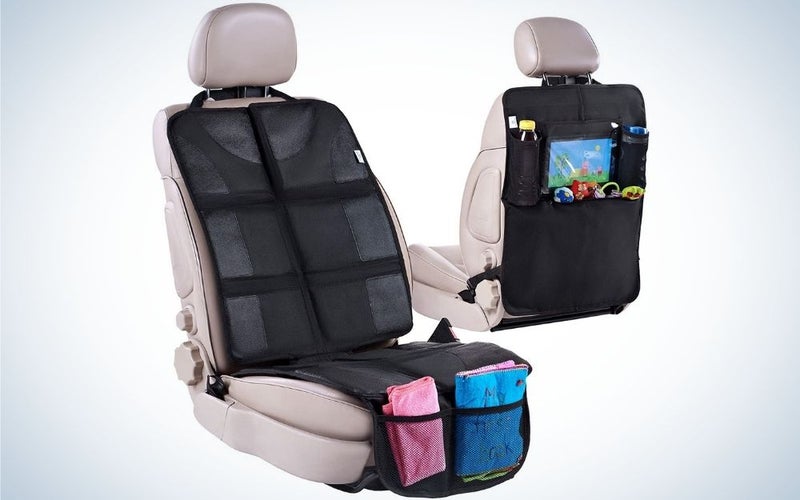 Two beige car seat with black covers in front of them and toys and pads at back of them.