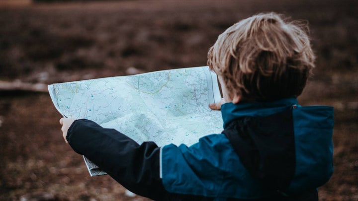A child holding a map outdoors.