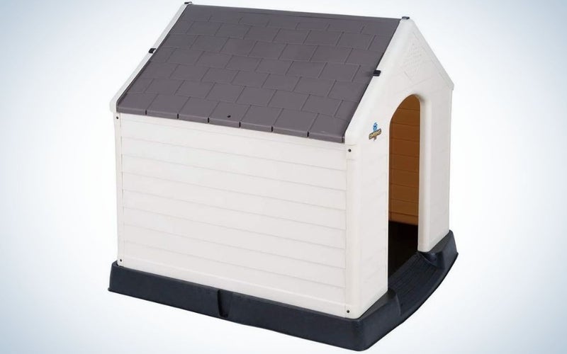 A dog outdoor house designed like a small house with white walls and black roof and floor.