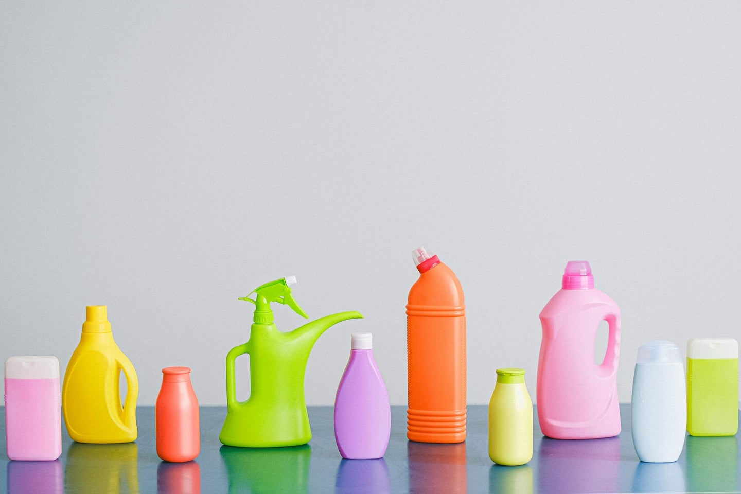Colorful cleaning products on blank background.
