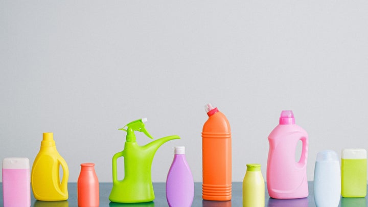 Colorful cleaning products on blank background.