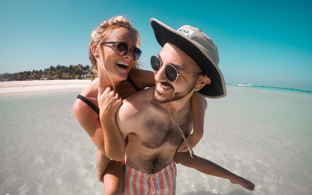 A couple on the beach wearing sunglasses