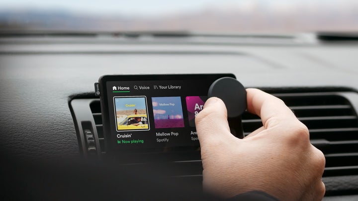 A person controls a knob on Spotify's Car Thing device.