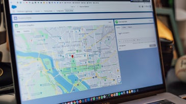 A laptop open with an image of Google Maps on the screen.