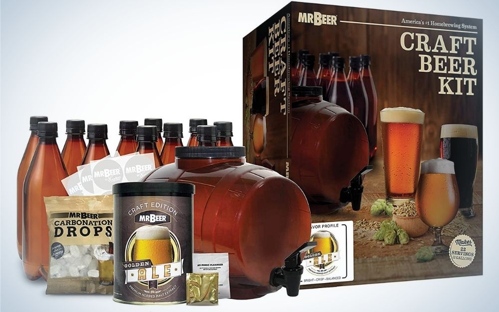 A beer maker with some brown bottles and a box with relevant instructions.