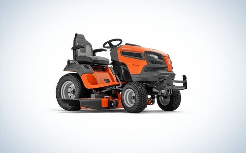 A orange and black lawn mower with 4 black wheels and a black seat as well.