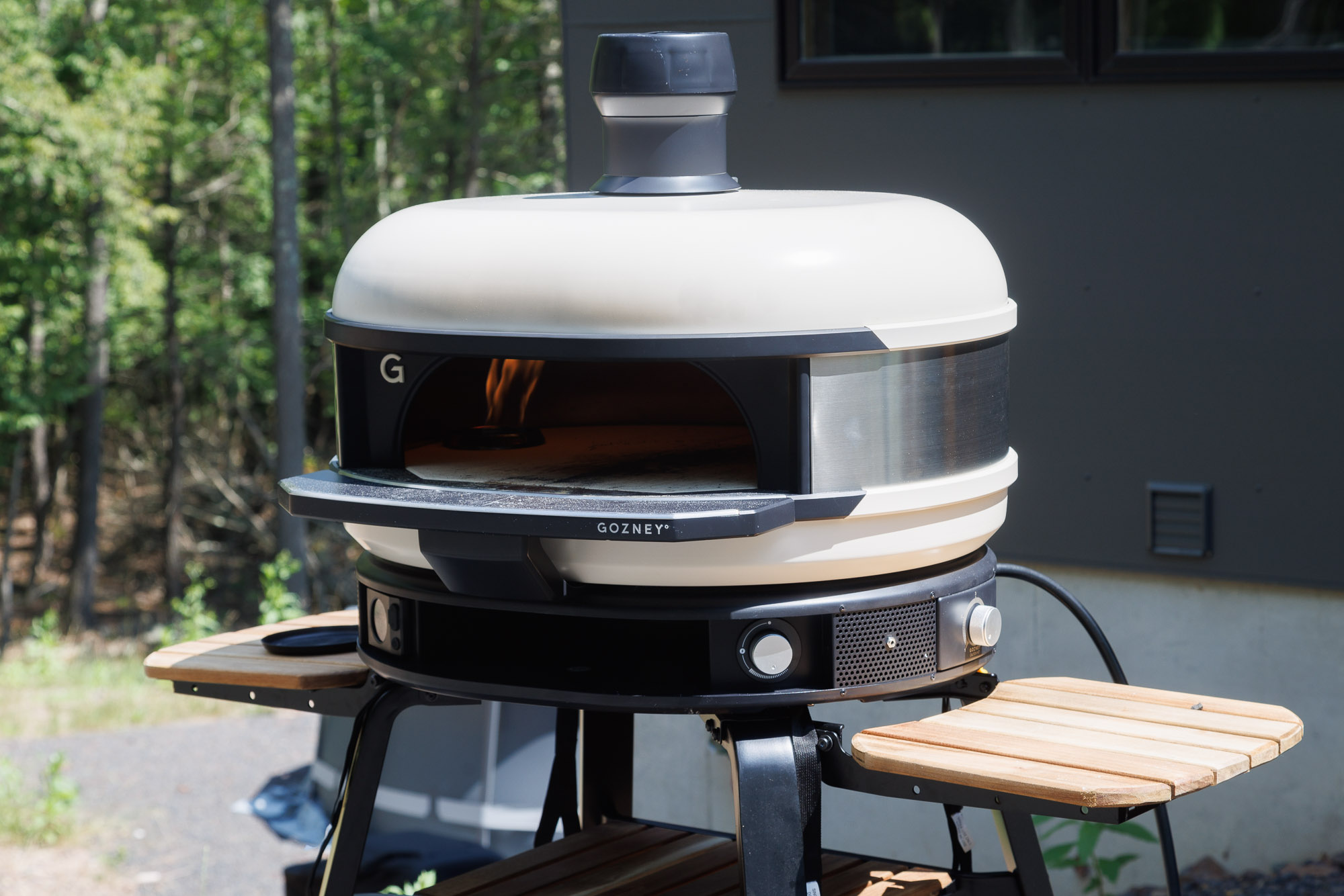 Gozney Dome pizza oven with fire inside outdoors
