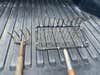 Wooden rake and metal clam fork in a truck bed