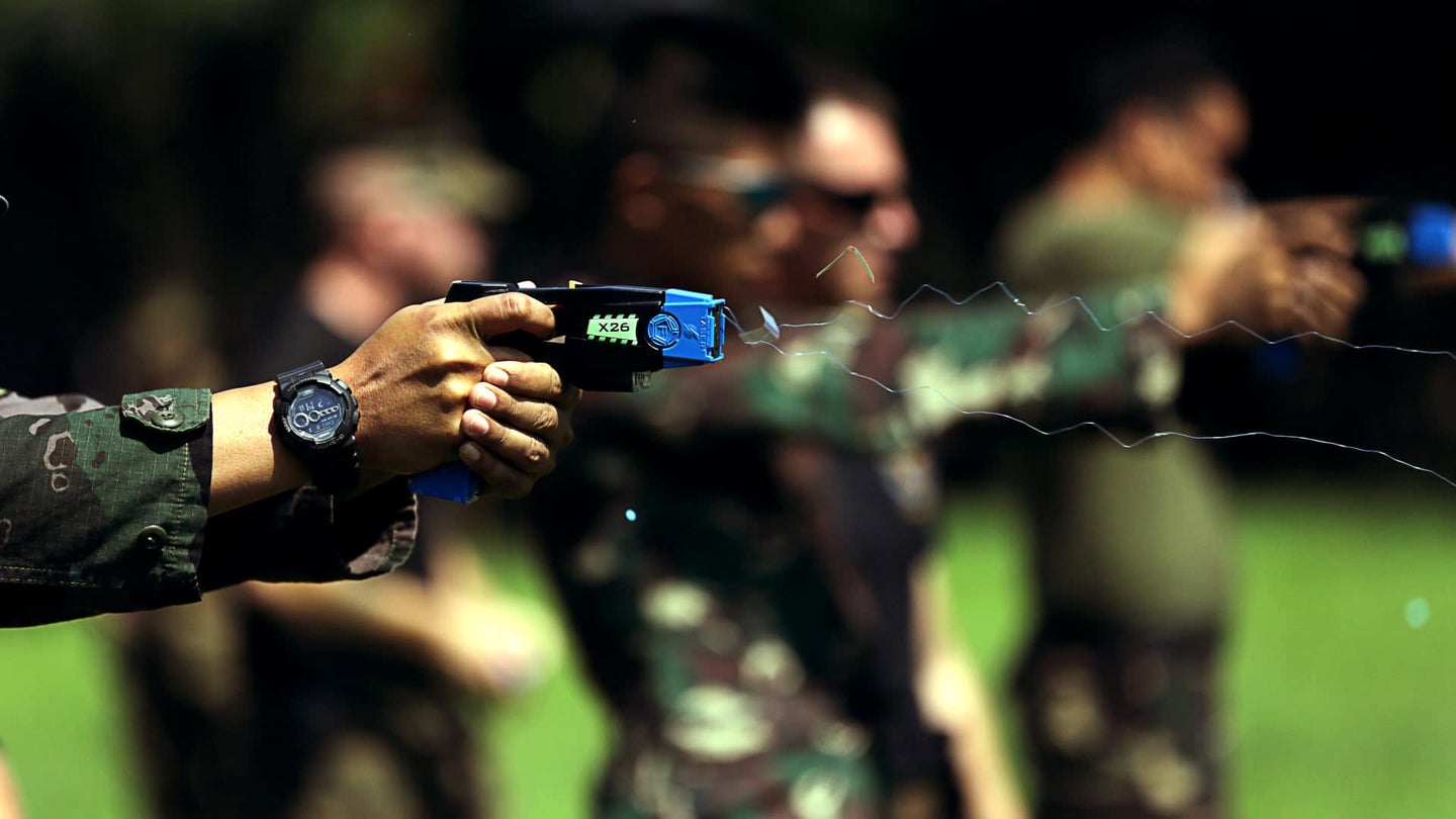 Military member shooting a blue Taser