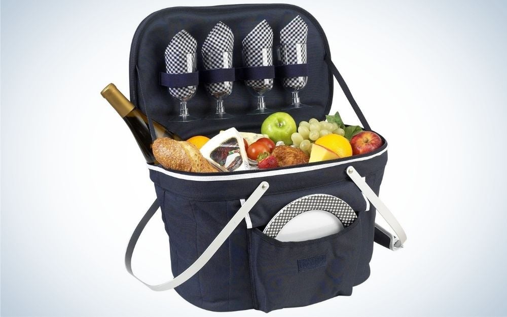 Navy picnic basket with padded handles filled with plate, wine glasses, and food
