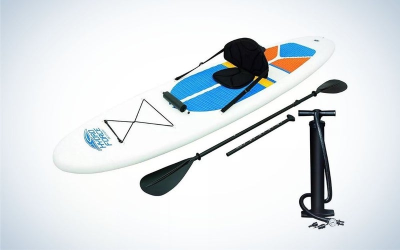 White inflatable stand-up paddleboard with black hand pump, bag, and paddles