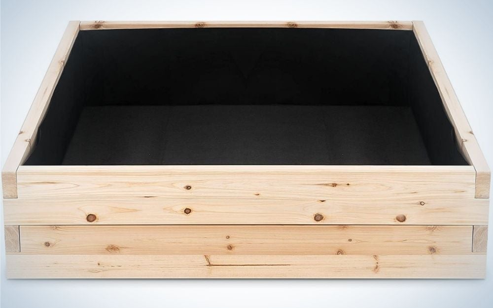 The structure of a wooden square garden bed and a black cover from the inside, all in a square shape.
